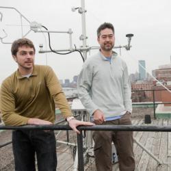 Graduate student Jared Newell, left, and Nathan Phillips on the roof of the Stone Science Building